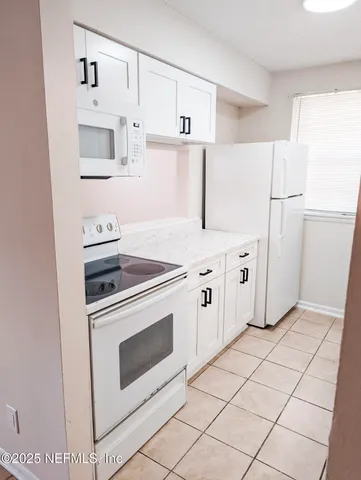 a kitchen with cabinets and white appliances