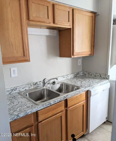 a kitchen with granite countertop a sink and a stove