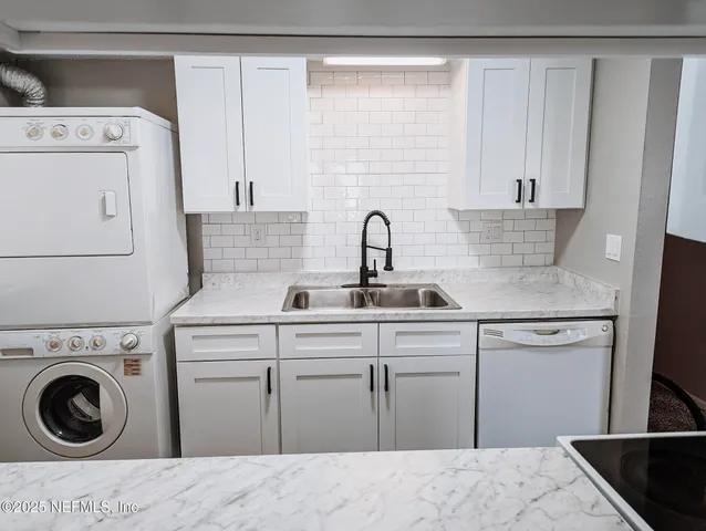 a kitchen with a sink and a washer dryer