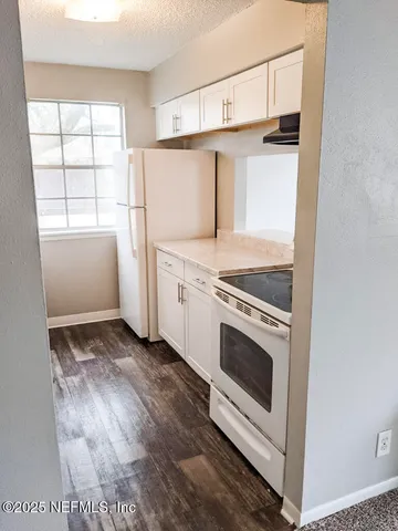 a kitchen with cabinets appliances and a window