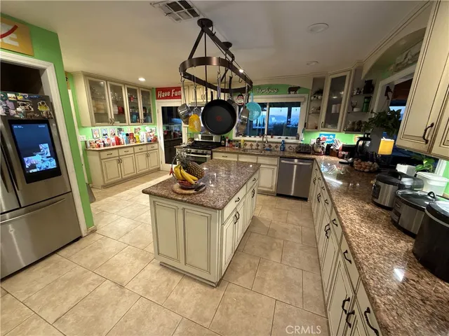a kitchen with stainless steel appliances granite countertop a stove a sink and a refrigerator