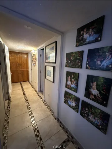 a view of a hallway with workspace and lots of painting on the wall