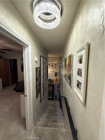 a view of a hallway with a large kitchen space