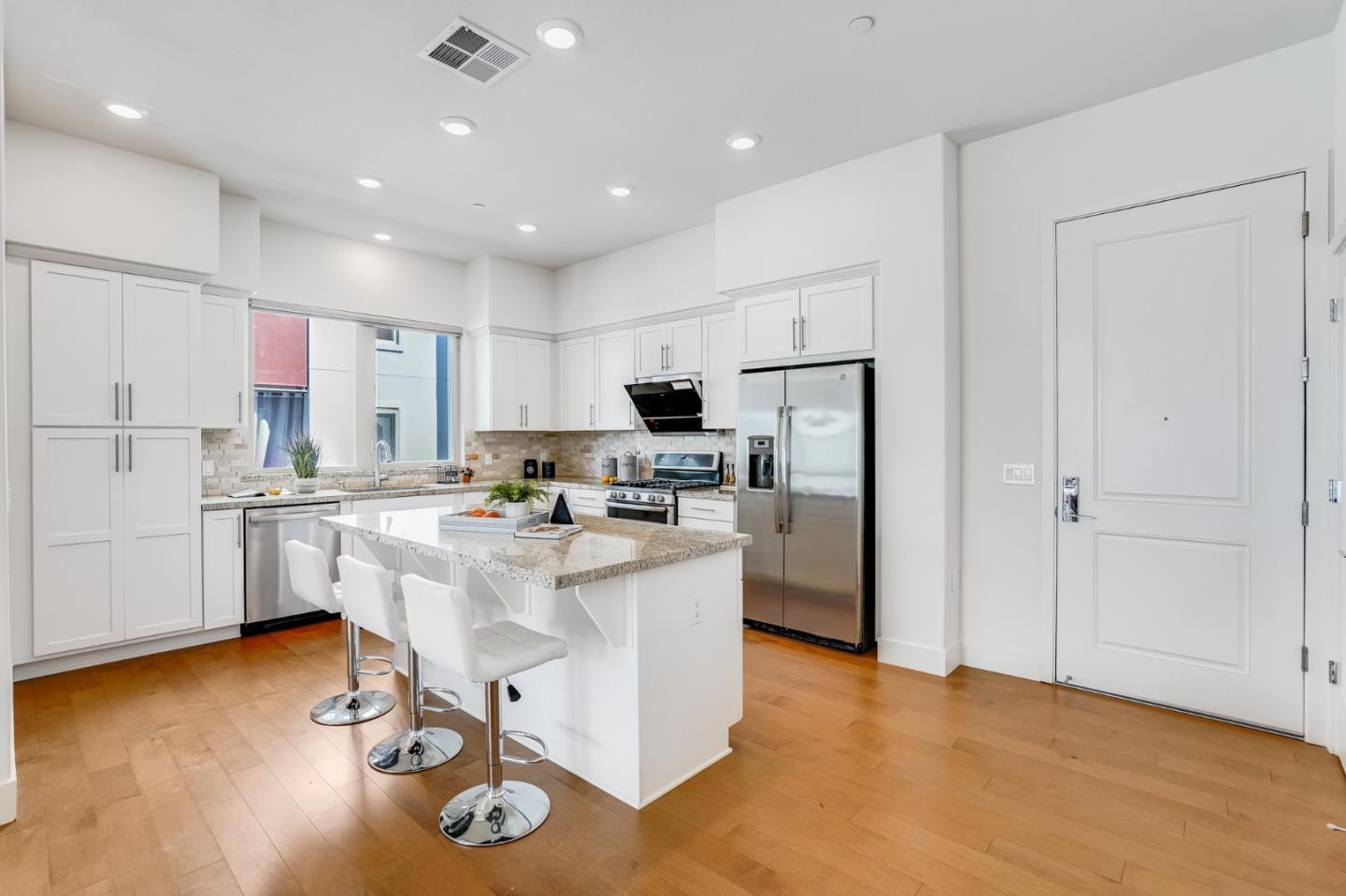360 Riesling Avenue, Unit 32 Milpitas, CA 95035 - Photo 9 of 32 a kitchen with stainless steel appliances granite countertop a refrigerator oven a sink dishwasher and a refrigerator with wooden floor