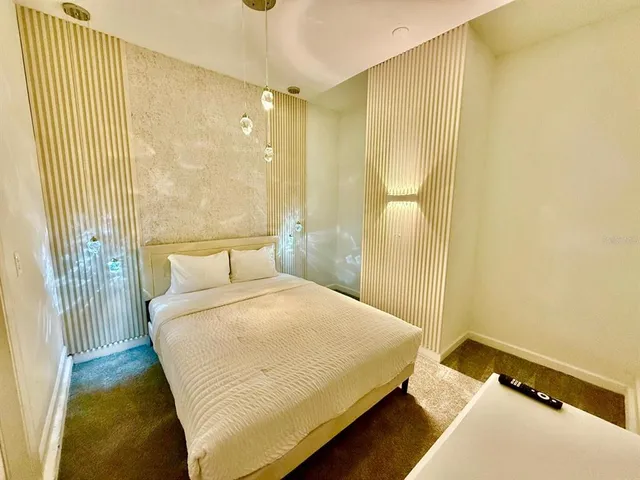 a bed sitting in a bedroom and painting on the wall