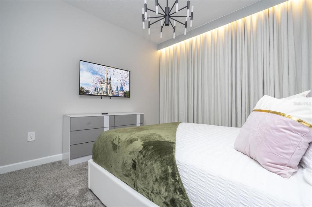 8964 Takeaway Way Davenport, FL 33896 - Photo 23 of 71 a bed sitting in a bedroom and painting on the wall