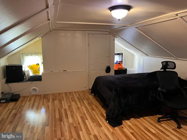 a bedroom with a bed and a flat tv screen on a dresser