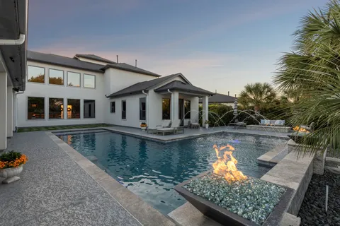a view of a house with pool and a yard