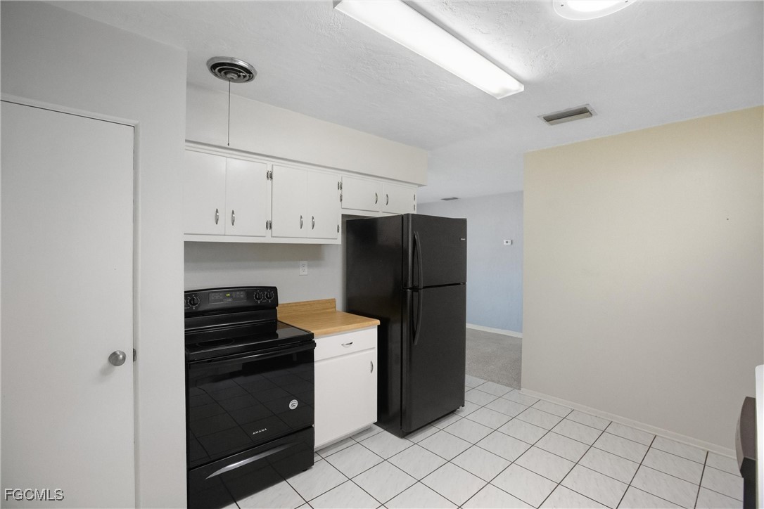 1440 Mandel Road Fort Myers, FL 33919 - Photo 6 of 40 a kitchen with a refrigerator and cabinets