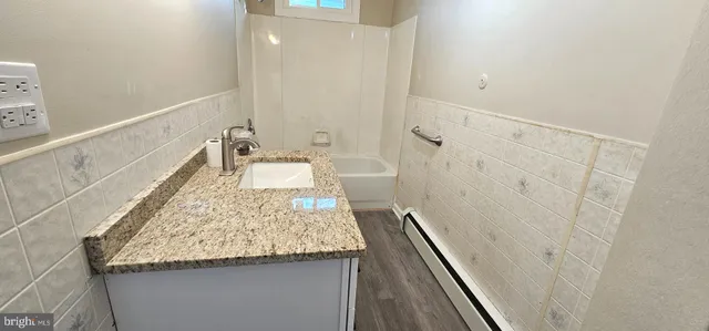 a bathroom with a granite countertop sink and a mirror