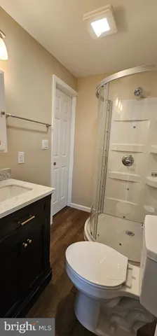 a bathroom with a sink a toilet a mirror and shower