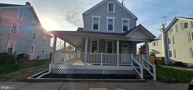 a view of a house with a small yard and wooden fence