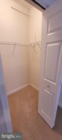 an empty room with closet and windows