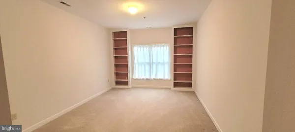 a view of an empty room with a fireplace and a window