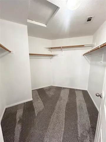 a view of walk in closet with empty racks