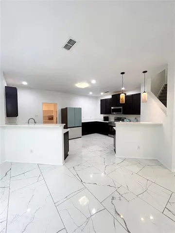 a kitchen with stainless steel appliances kitchen island sink refrigerator and microwave
