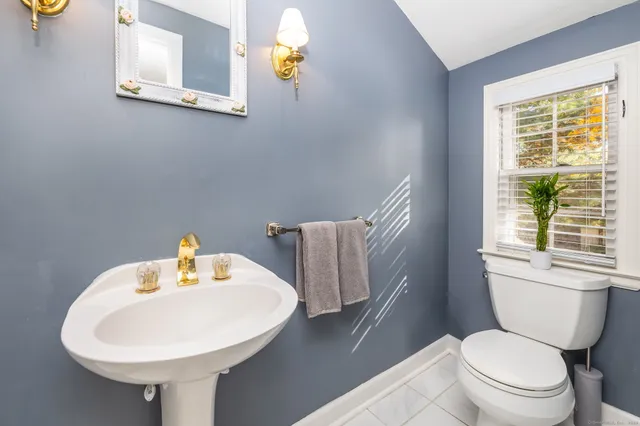 a bathroom with a sink a toilet and a mirror