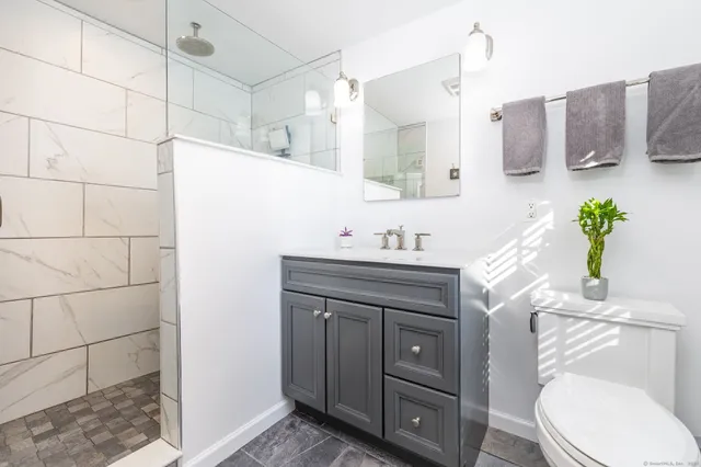 a bathroom with a sink vanity granite and toilet