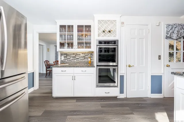a kitchen with stainless steel appliances kitchen island granite countertop a refrigerator and a stove