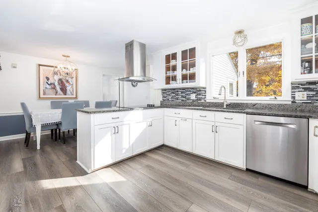 a kitchen with stainless steel appliances sink cabinets and wooden floor