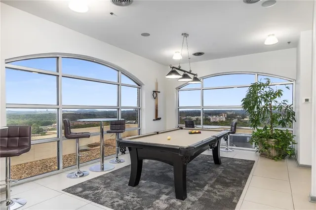 a living room with stainless steel appliances a stove a sink a microwave a refrigerator and cabinets