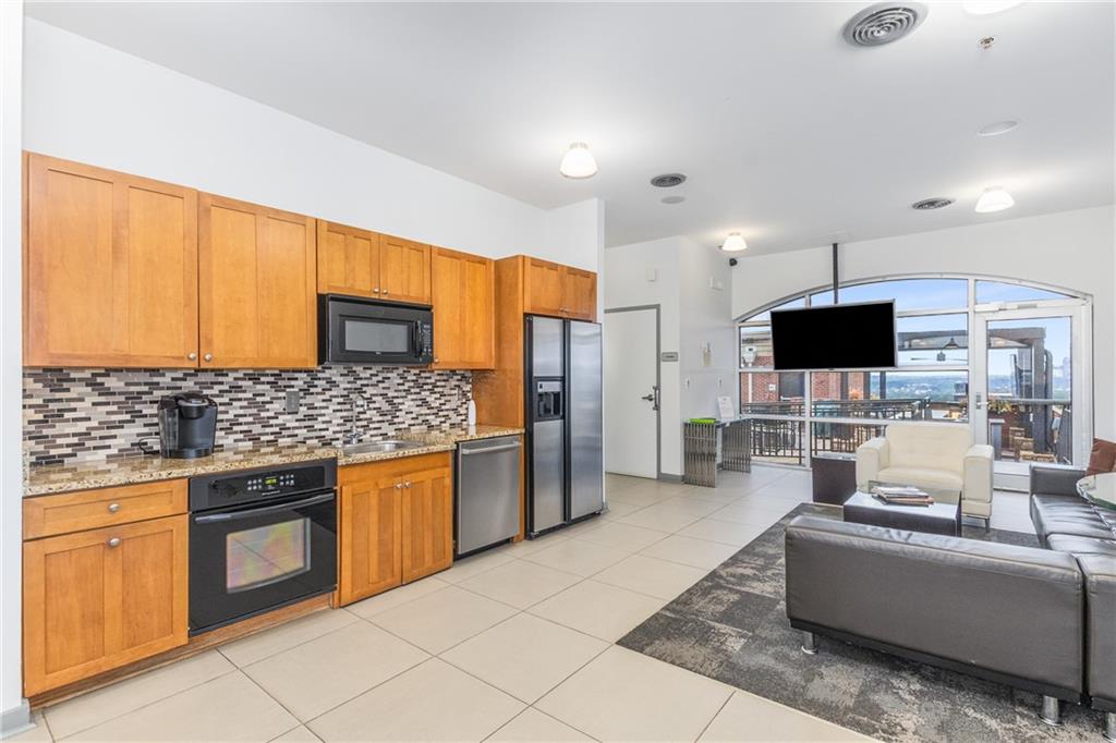 3180 Mathieson Drive Northeast, Unit 1010 Atlanta, GA 30305 - Photo 32 of 44 a living room with stainless steel appliances a stove a sink a microwave a refrigerator and cabinets