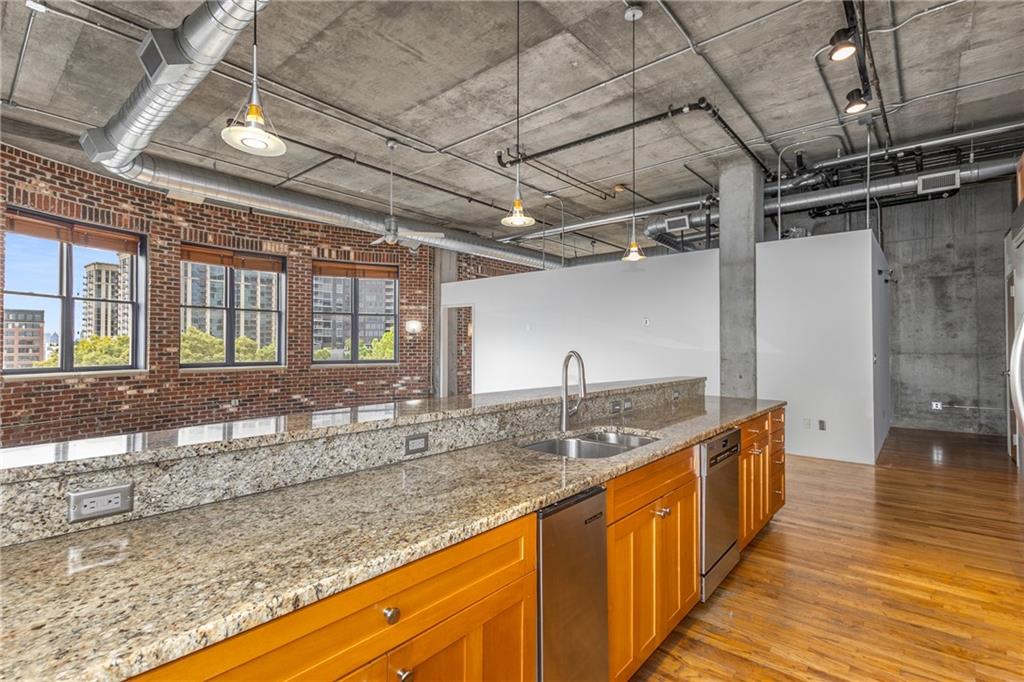 3180 Mathieson Drive Northeast, Unit 1010 Atlanta, GA 30305 - Photo 10 of 44 a kitchen with stainless steel appliances granite countertop a sink and wooden cabinets