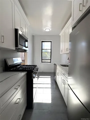 a kitchen with stainless steel appliances a sink dishwasher stove microwave and cabinets