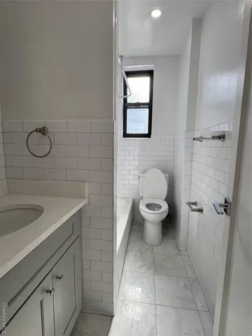 a spacious bathroom with a granite countertop sink a toilet and a shower