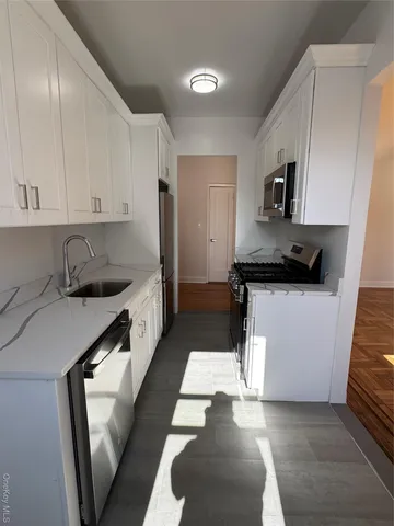 a kitchen with granite countertop a sink a stove and cabinets