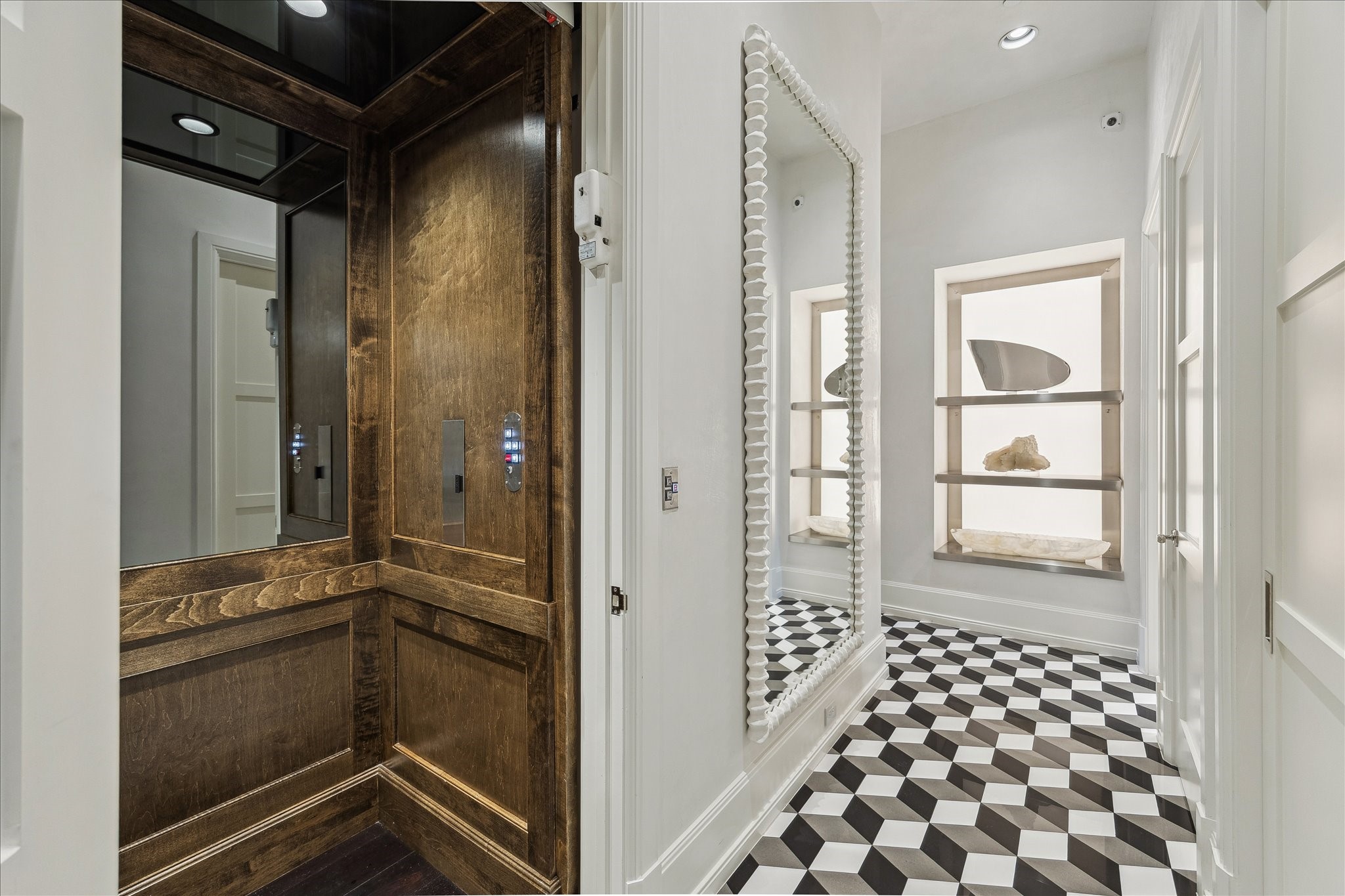 220 Merrie Way Lane Houston, TX 77024 - Photo 19 of 50 The elevator landing delivers a stylish flair with designer black-and-white tiled flooring and a built-in display niche, creating a clean, polished moment of both style and utility.