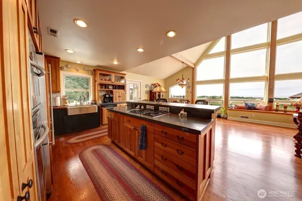 a kitchen with stainless steel appliances granite countertop sink stove and large window