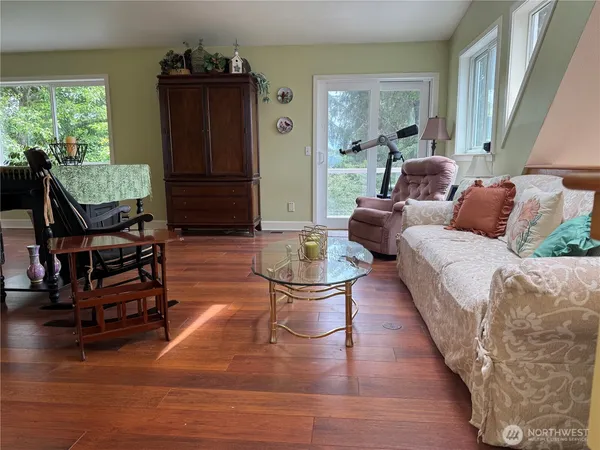 a living room with furniture a wooden floor and a large window