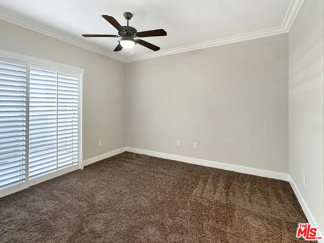 an empty room with a window and a ceiling fan