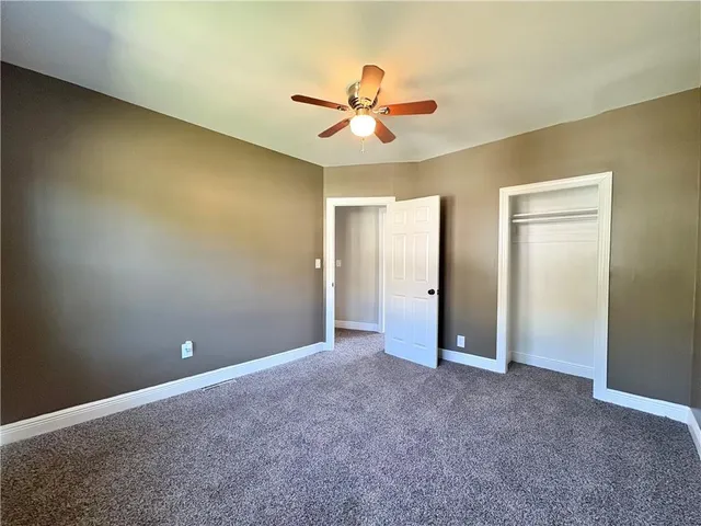 a view of an empty room with a ceiling fan