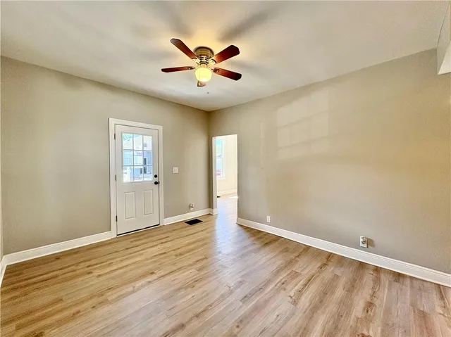 an empty room with wooden floor and windows