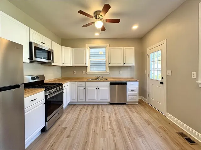 a kitchen with stainless steel appliances granite countertop a stove a sink and a microwave