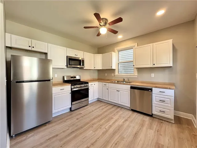a kitchen with stainless steel appliances a refrigerator sink and microwave