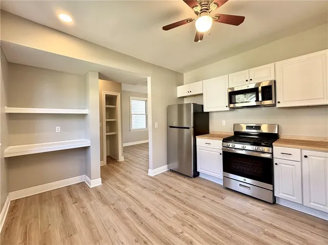 a kitchen with stainless steel appliances a stove a refrigerator and a microwave