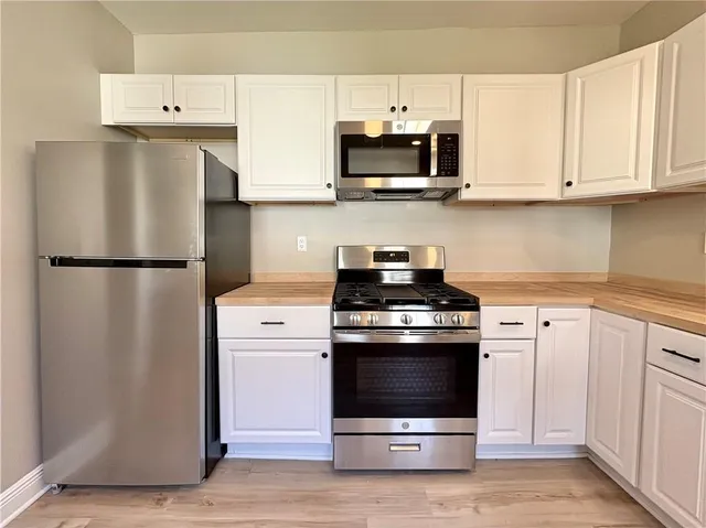 a kitchen with white cabinets and stainless steel appliances