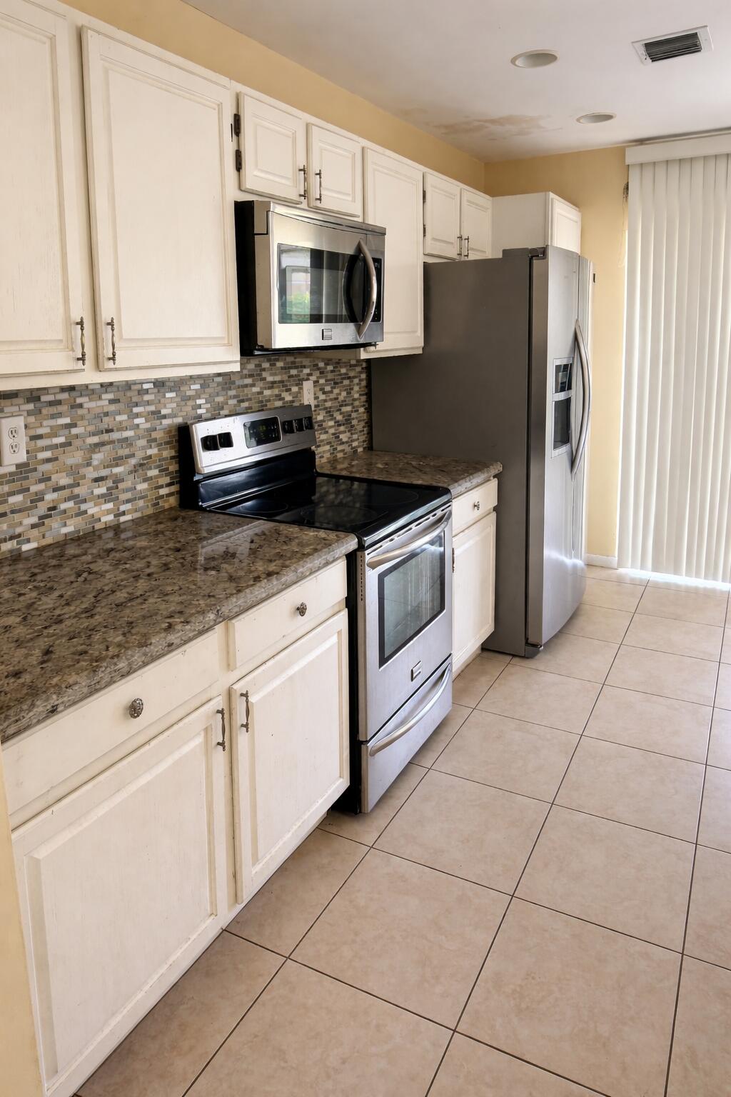 5302 Sapphire Valley Boca Raton, FL 33431 - Photo 3 of 13 a kitchen with granite countertop a refrigerator stove and microwave