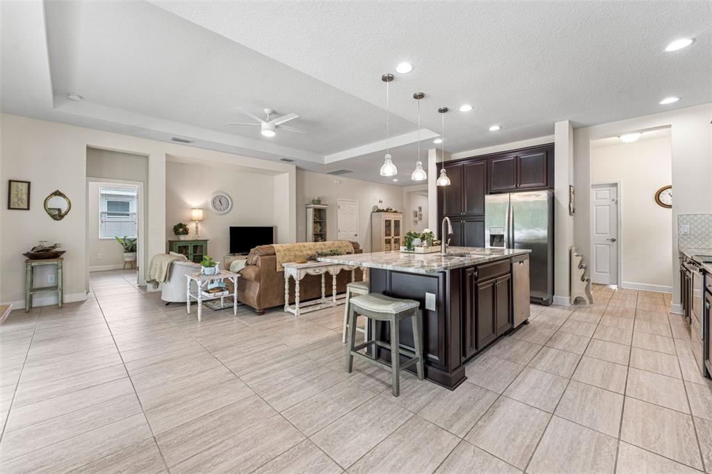 1237 Windy Bay Shoal Tarpon Springs, FL 34689 - Photo 20 of 44 a living room with couches and kitchen view with wooden floor