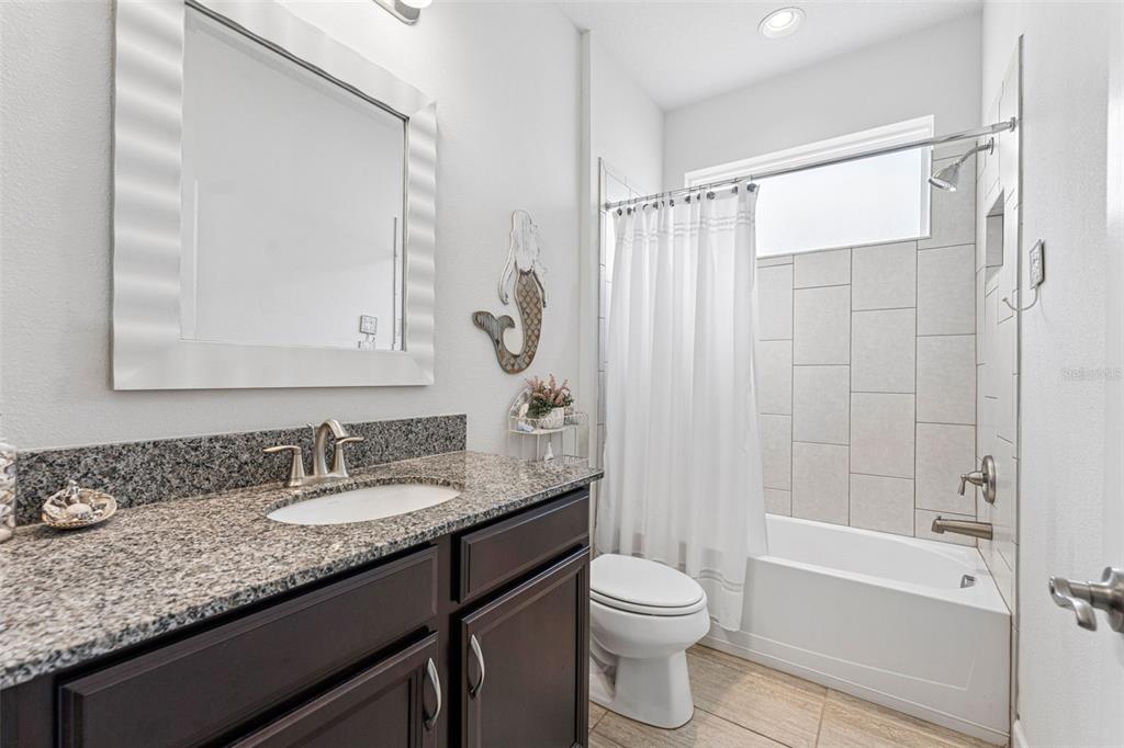 1237 Windy Bay Shoal Tarpon Springs, FL 34689 - Photo 28 of 44 a bathroom with a granite countertop sink toilet and shower