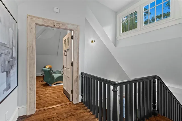 a view of a hallway with wooden floor and stairs