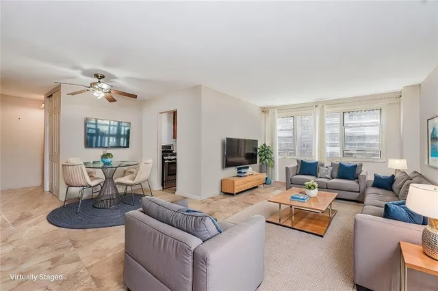 a living room with furniture flat screen tv and large window