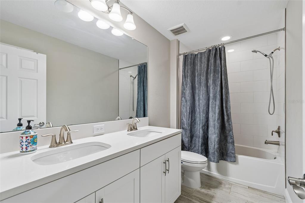 4300 Burdick Loop Odessa, FL 33556 - Photo 22 of 41 a bathroom with a double vanity sink toilet mirror and shower