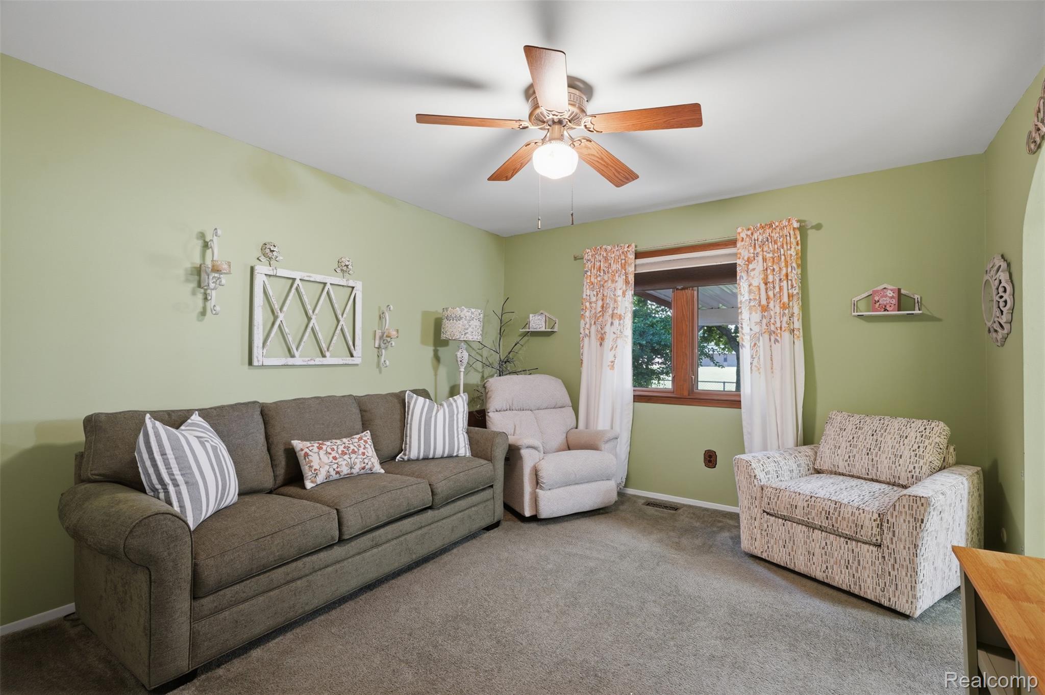 18160 Raleigh Square Drive Southgate, MI 48195 - Photo 10 of 31 Living area featuring wood-finish window trim, a ceiling fan with integrated lighting, and carpet flooring