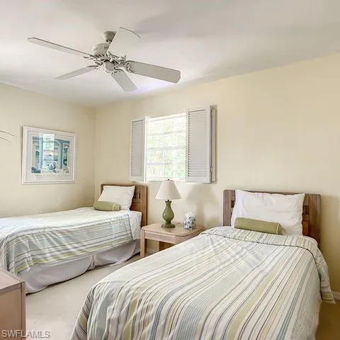 a bedroom with two beds and a window