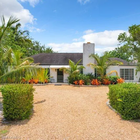 a front view of a house with a yard and potted plants