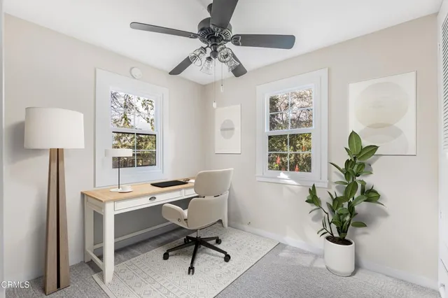 a view of a workspace with furniture and a window